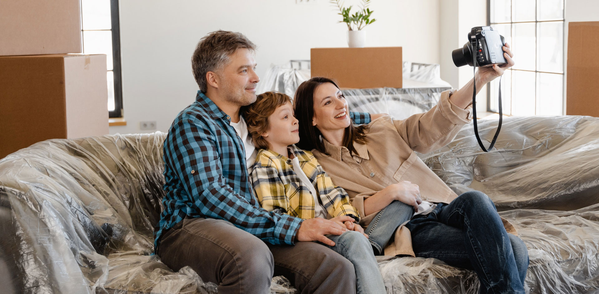 A family taking their photo on a sofa in their new home